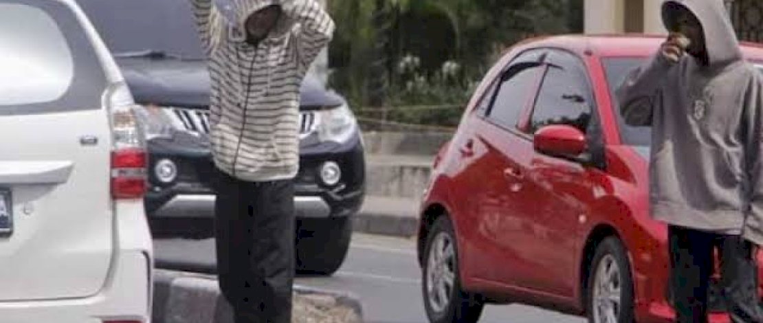 Pak Ogah sedang beroperasi membantu pengendara di jalaur U Turn untuk mutar balik mobil dan motor jadi biang kemacetan di Makassar.