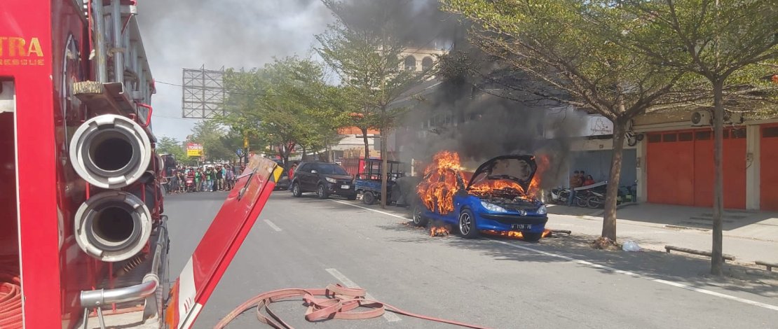 Sebuah mobil berlogo singa terbakar di Makassar