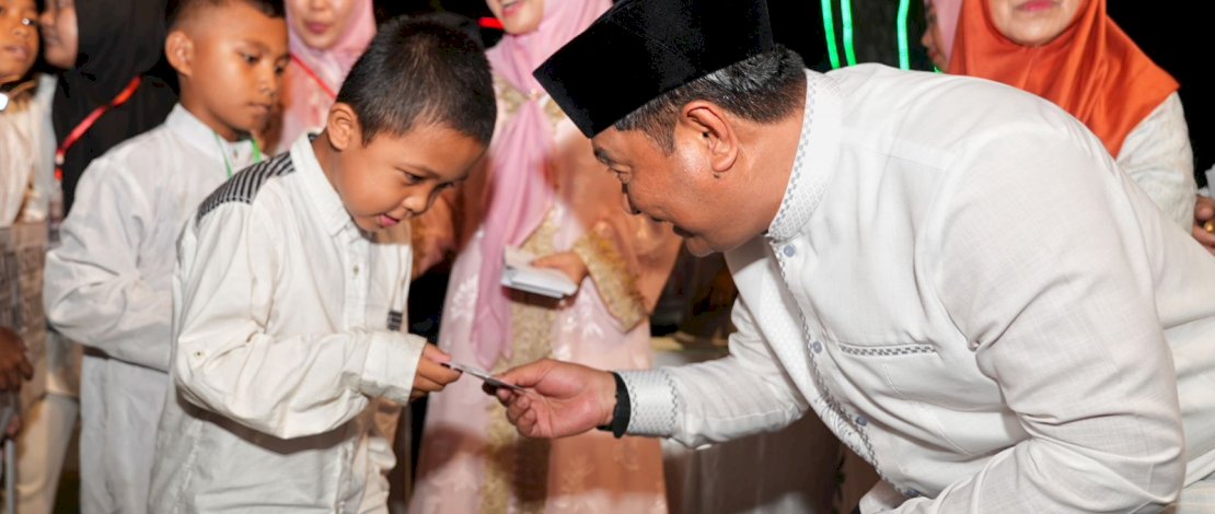 Pj Gubernur Bahtiar Baharuddin saat menyerahkan santunan kepada anak yatim.