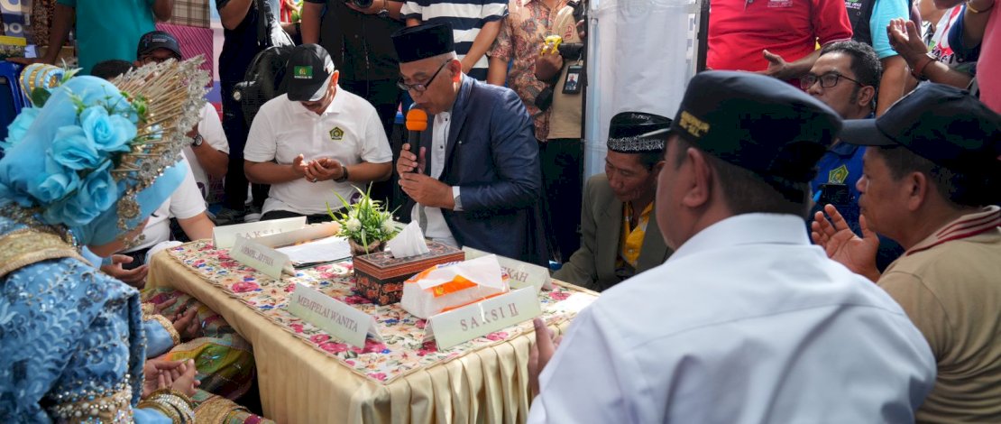Penjabat Gubernur Sulsel, Bahtiar Baharuddin, bersama Plt Kakanwil Kemenag Sulsel, Ali Yafid, menjadi saksi pada pernikahan yang digelar Kemenag Sulsel di salah satu stand pada Peringatan Hari Amal Bakti (HAB), di Lapangan Citra Mas Kabupaten Pangkep, Minggu, 7 Januari 2024. 