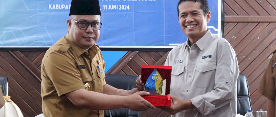 Sekda Mesdiyono menyerahkan cinderamata kepada Deputi Kepala Perwakilan Wilayah Bank Indonesia Provinsi Sulawesi Selatan Ricky Satria, pada High Level Meeting dalam rangka Percepatan dan Perluasan Digitalisasi Daerah. 