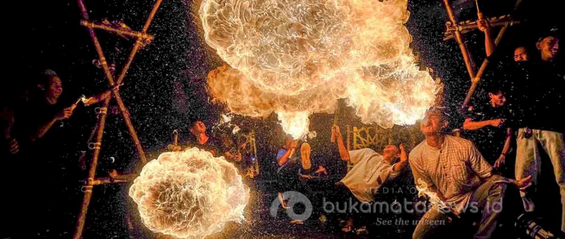Para pemuda melakukan atraksi semburan api diiringi dengan pawai obor dalam rangka memeriahkan malam takbiran jelang Idhul Fitri 1446 Hijriah di Makassar, Minggu (30/3/2025). (foto:Muchtamir Zaide)