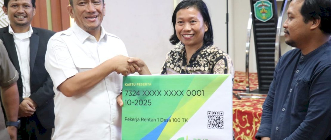 Bupati Luwu Timur Irwan Bachri Syam secara simbolis menyerahkan kartu BPJS Ketenagakerjaan kepada salah satu perwakilan pekerja rentan, Jumat, 5 Desember 2025.