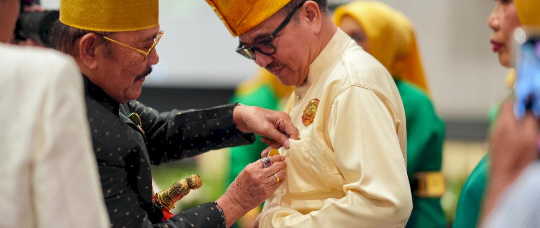 Sekretaris Daerah Provinsi Sulsel, Jufri Rahman, yang juga menjabat sebagai Ketua Dunia Melayu Dunia Islam Sulsel, menerima penyematan pin sebagai tanda kehormatan dari Ketua Agung Majelis Keturunan To Manurung Sulsel, Andi Pamadengrukka Mappanyompa.