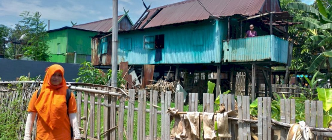 Andi Nirawati di depan salah satu rumah kaum dhuafa yang tidak tersentuh Bansos.