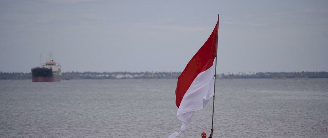 Suasana Spiderman Indonesia Parepare mengibarkan bendera raksasa di tengah laut.
