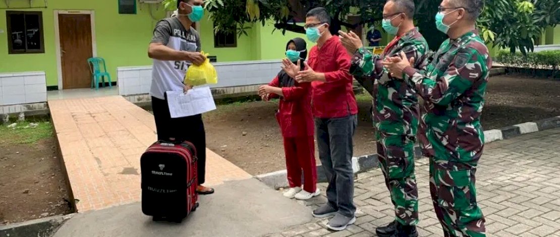 Dokter dan perawat memberi aplaus ke seorang pasien Covid-19 yang sembuh.