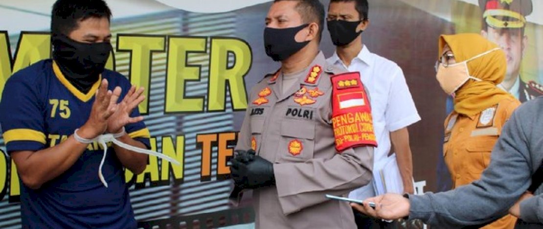 AS (kiri), dukun cabul saat diamankan Polresta Depok.