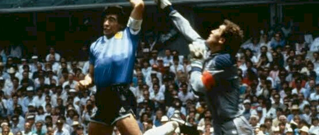Foto legendaris Maradona saat menjebol gawang lawan dengan tangannya.