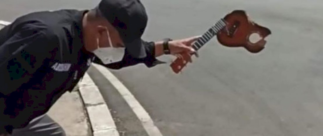 Seorang oknum Satpol PP hancurkan gitar pengamen. (Sumber: Handout) Seorang oknum Satpol PP hancurkan gitar pengamen. (Sumber: Handout)