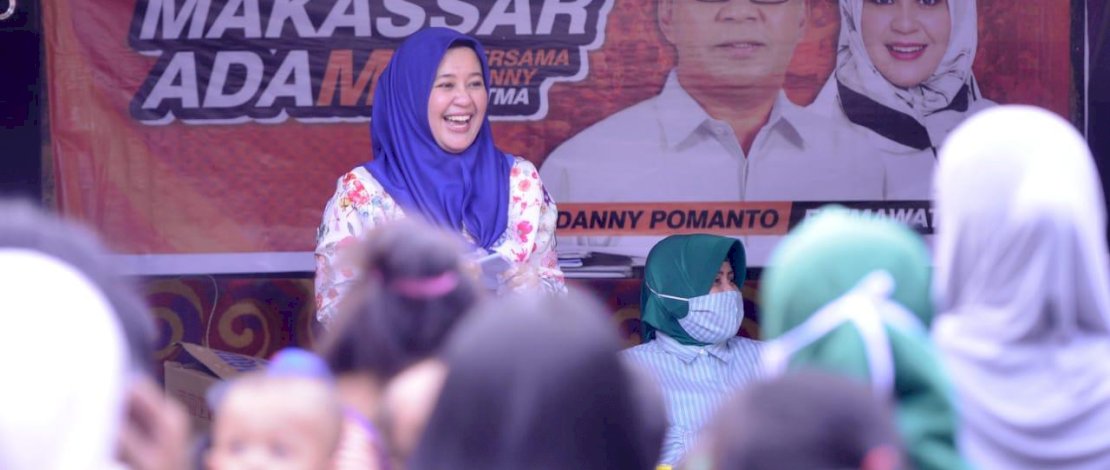 Fatma memasangkan masker ke salah seorang warga.