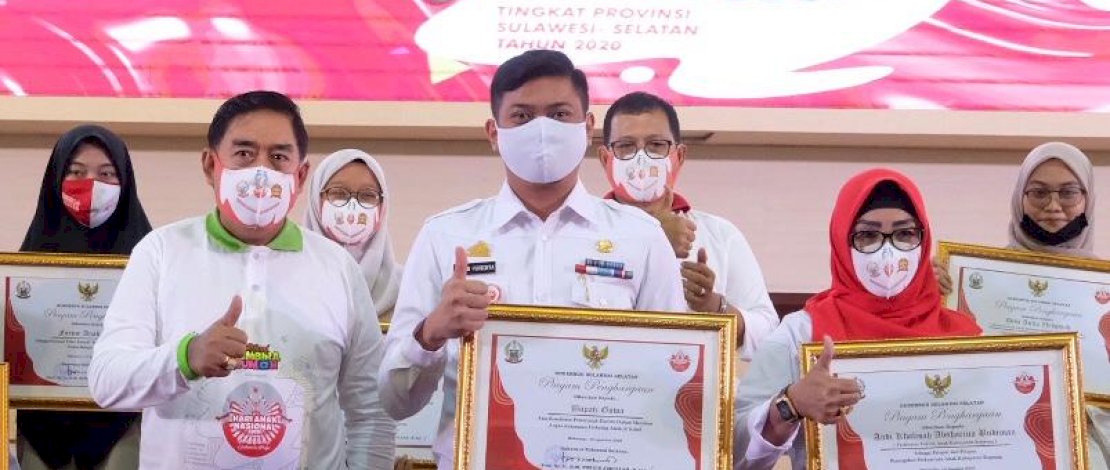 Bupati Gowa, Adnan Purichta Ichsan memperlihatkan piagam penghargaan yang dia terima.