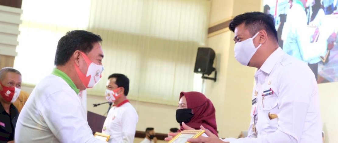 Bupati Gowa, Adnan Purichta Ichsan memperlihatkan piagam penghargaan yang dia terima.