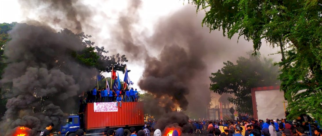 Mahasiswa Unismuh membakar ban bekas di depan kampus mereka.