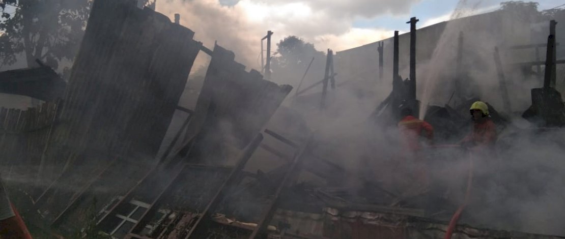 Pemadam bersama petugas kepolisian dan warga, berusaha memadamkan api.