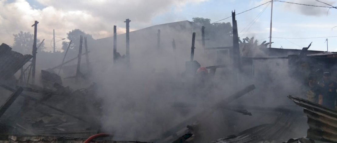 Pemadam bersama petugas kepolisian dan warga, berusaha memadamkan api.