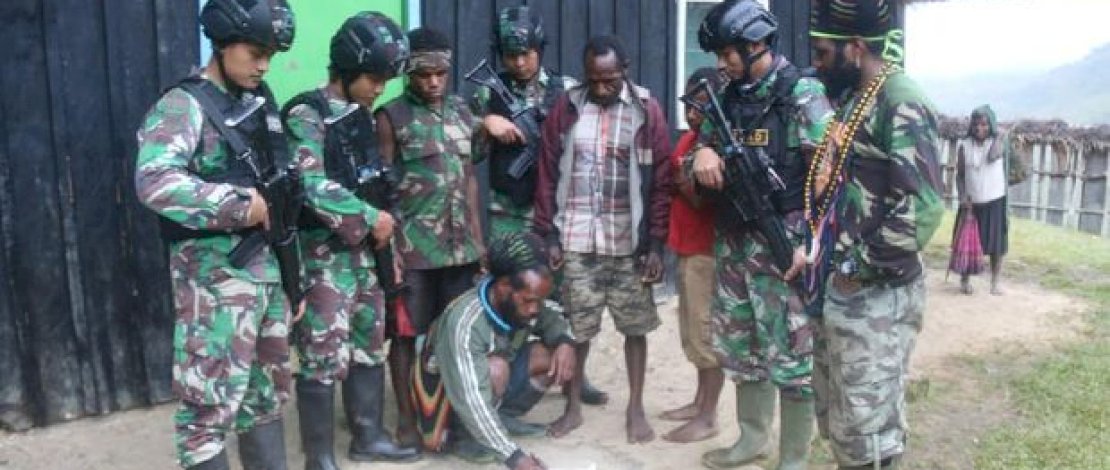 Tenius Tebuni memegang bendera merah putih, saat berikrar kembali ke NKRI.