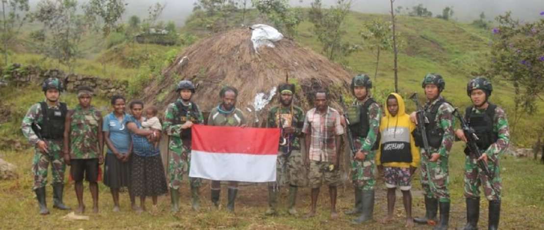Tenius Tebuni memegang bendera merah putih, saat berikrar kembali ke NKRI.