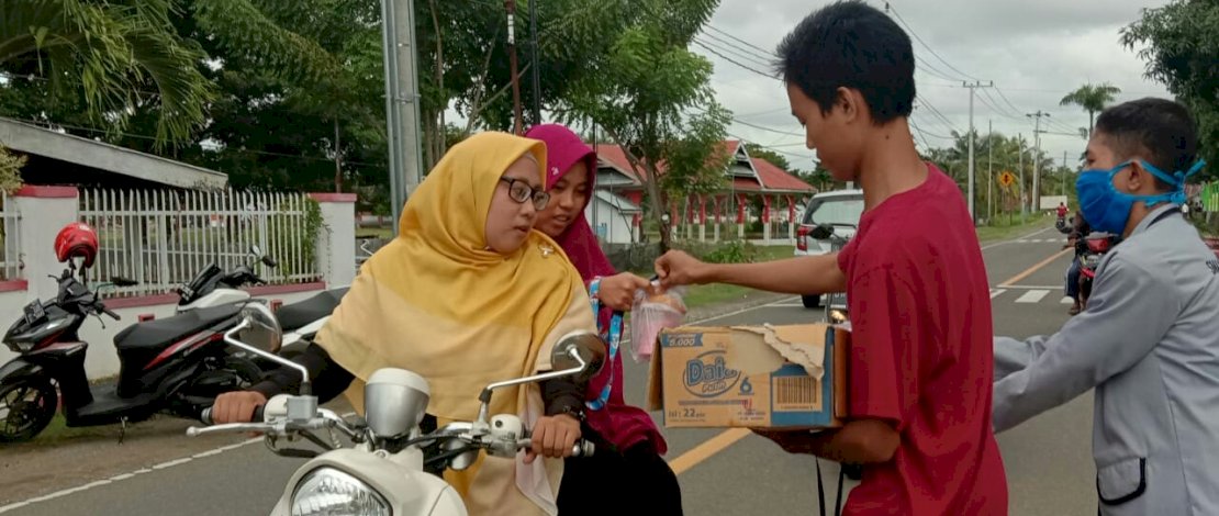 OSIS SMA 8 Bone, membagikan takjil kepada pengendara yang lewat.
