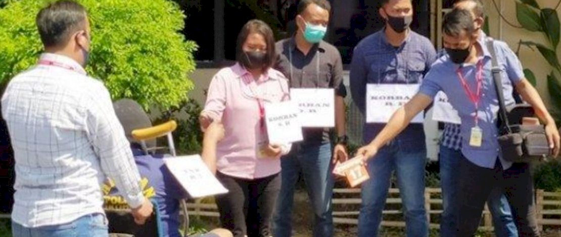 Henry Taryatmo duduk di kursi roda saat memeragakan adegan 17, ketika membunuh korban dengan pisau.