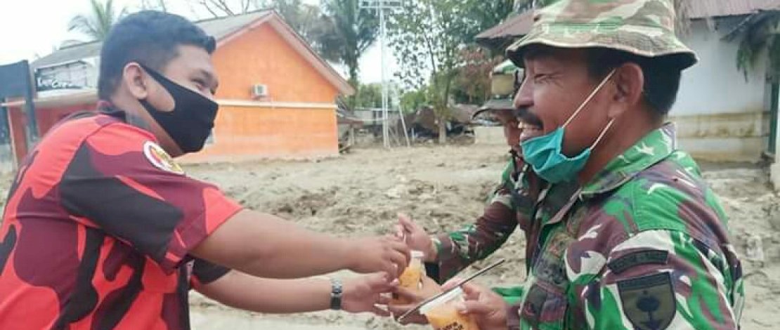 Pengurus Pemuda Pancasila Luwu Utara, membagikan makanan olahan kepada relawan dari TNI.