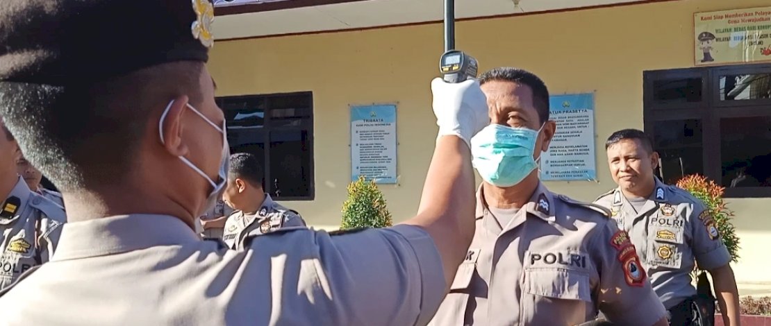 Tim UR Dokkes Wira Bhayangkara Polres Gowa saat melakukan pemeriksaan suhu badan bagi anggota personil Polres Gowa di tengah mewabahnya virus corona di Indonesia. 