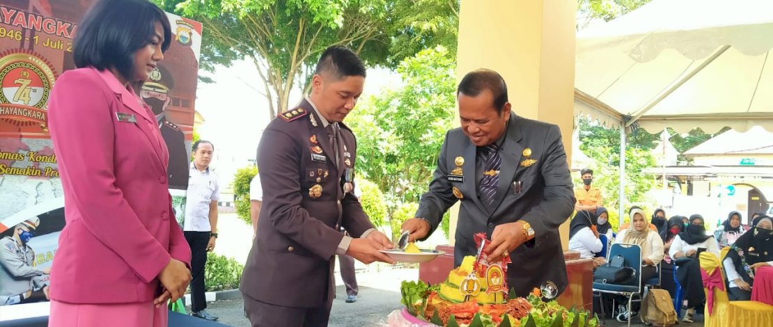 Bupati Luwu, H Basmin Mattayang, memotong tumpeng pada HUT Bhayangkara ke-74 di Mapolres Luwu.