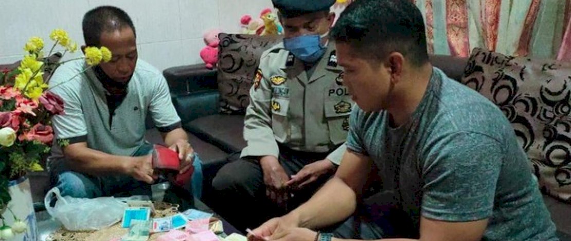 Gani (kiri), mengembalikan uang Rp12 juta yang dia temukan ke pemiliknya.