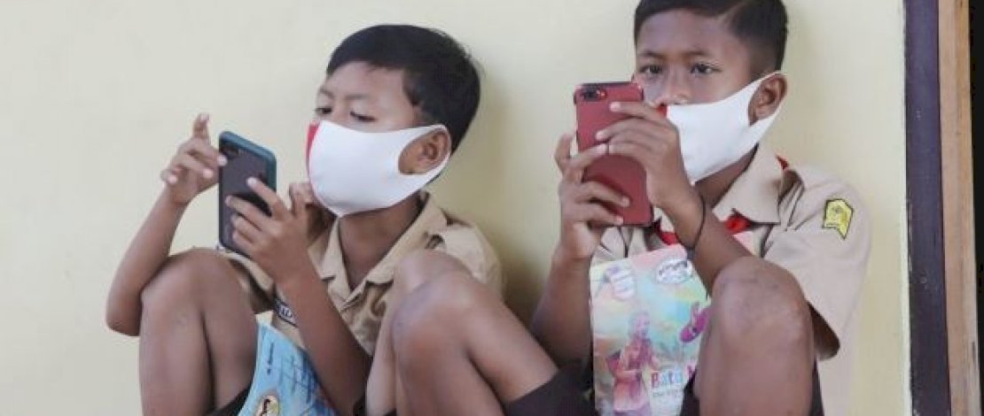 Dua anak sedang belajar daring. (Sumber: Tribunnews)