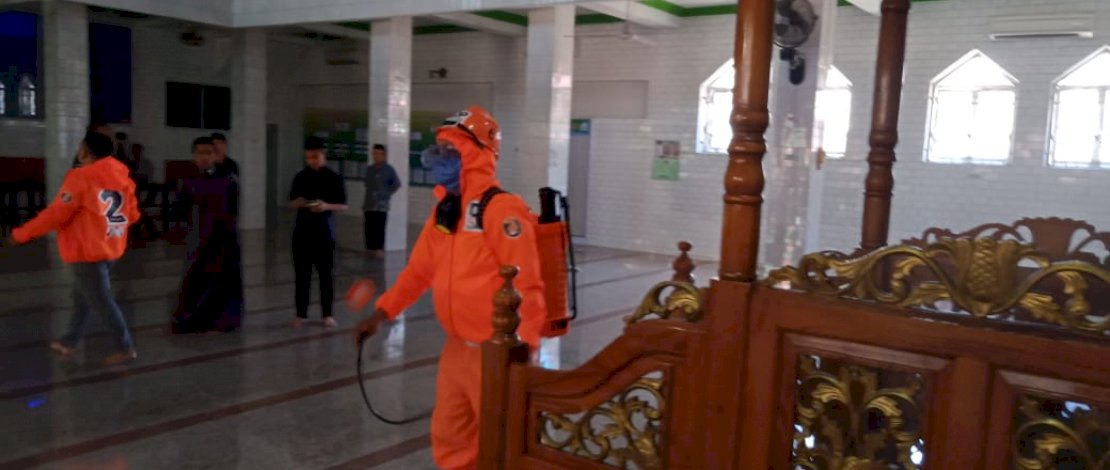 Tim Danny Pomanto Peduli Corona tengah menyemprotkan disinfektan di dalam masjid.