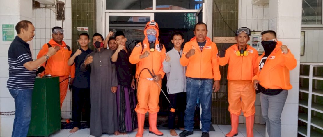 Tim Danny Pomanto Peduli Corona tengah menyemprotkan disinfektan di dalam masjid.