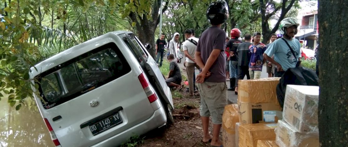 Sebuah mobil silver nyaris masuk ke sungai usai menghindari tabrakan dari sepeda motor yang menyalip.
