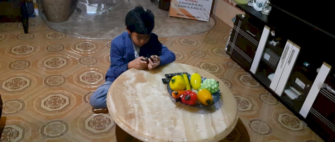 Salah seorang siswa SMP Islam Al Akhyar, tengah mengerjakan soal dari smartphonenya.