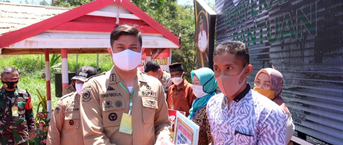 Bupati Gowa, Adnan Purichta Ichsan menyerahkan bansos beras kepada warga.