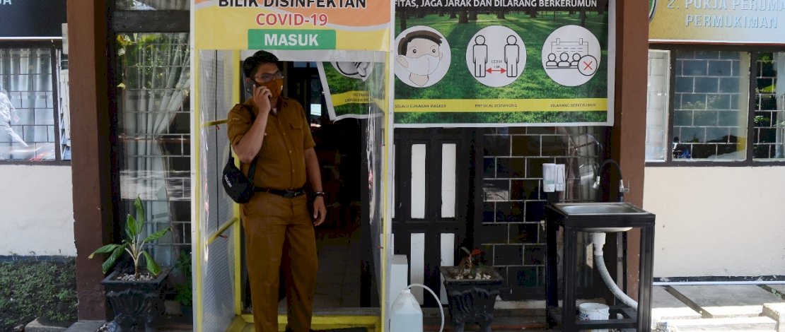 Sejumlah pegawai mencuci tangan dan membasuh diri di gerbang disinfektan yang disediakan di Kantor Bappeda, Kota Parepare, Sulawesi selatan, Senin, 16 November 2020. Sejumlah perkantoran di Kota Parepare, menyediakan bilik disinfektan dan tempat cuci tangan untuk mencegah wabah virus Covid-19 menyebar luas. FOTOGRAFER/ZUL KIFLI