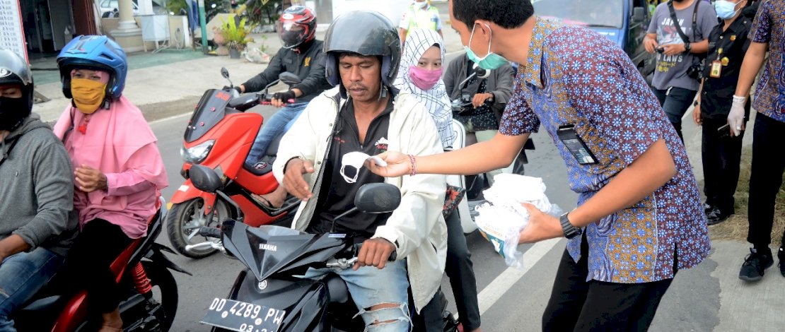 Pegawai PT. PLN Sektor Pembangkitan Bakaru Kota Parepare, membagikan masker kepada para pengendara di Jalan Trans Sulawesi Parepare, Pinrang, Kamis 19 November 2020. FOTOGRAFER/ZUL KIFLI